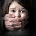 Scared young girl with an adult man's hand covering her mouth