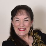 Head shot of Nancy Wyatt dressed in black with gold trim ready to teach meditation