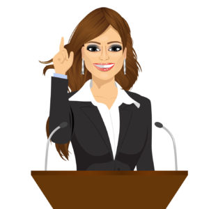 female orator standing behind a podium with microphones. Speaker