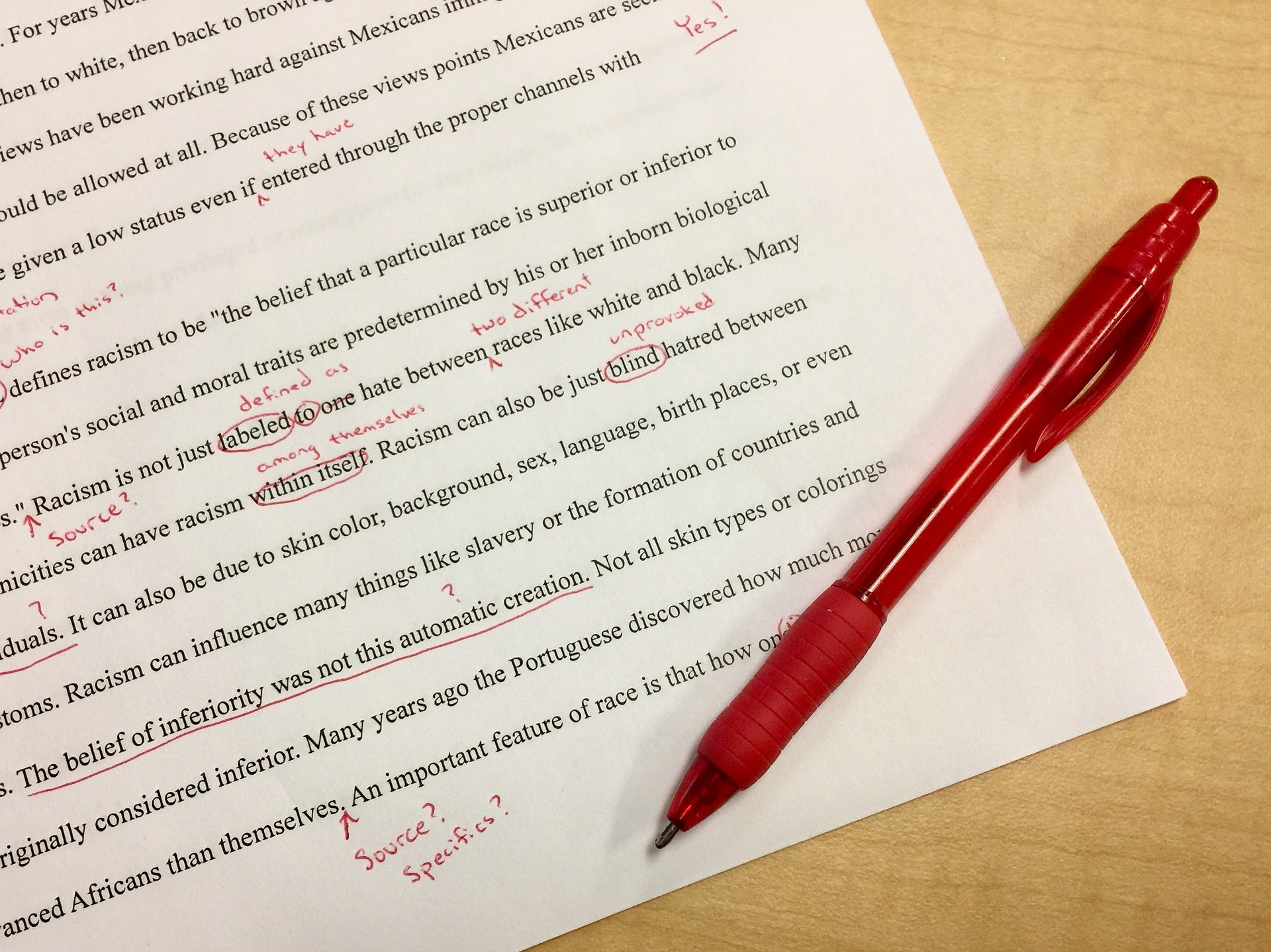 red pen and typed text on a page - proofreading, correcting mistakes by Anne Karakash