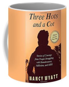 Three Hots and a Cot book cover on a coffee cup