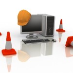 orange cones and computer screen with hard hat on it signifying site is under construction